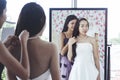 Reflection bride in mirror on wedding dress in a shop with bride Royalty Free Stock Photo