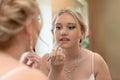 Reflection of bride in mirror who corrects her makeup,paints her lips with lipstick,concept of a wedding,a marriage Royalty Free Stock Photo