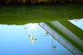 reflected bridge in green mirror calm water Royalty Free Stock Photo