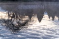 Reflection of a bridge and a tree in a pond during sunrise Royalty Free Stock Photo
