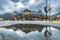 Reflection of a building with mountains in a puddle in the Village Square in Canmore, Alberta