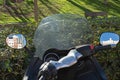 Reflection of buildings in a motorcycle mirror. Lazy day in a city park