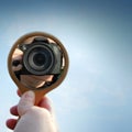 The reflection of the camera in the mirror on the background of a beautiful sky Royalty Free Stock Photo