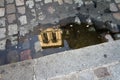 Reflection of the Catholic tower in a puddle on the pavement. Soft focus Royalty Free Stock Photo