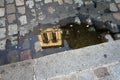 Reflection of the Catholic tower in a puddle on the pavement. Soft focus