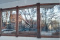 Reflection of city street in large windows of cafe. Lights of garlands, cars, trees in snow. Winter, Christmas holidays Royalty Free Stock Photo