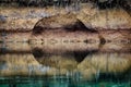 Reflection of a cliff on the surface of a calm river