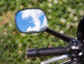 Reflection of clouds on a blue sky in a motobike mirror Royalty Free Stock Photo