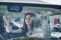 Reflection of clouds on the glass. Front view of woman that drives modern new car in the city Royalty Free Stock Photo