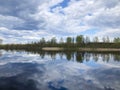 Reflection of clouds in the lake and the island in the distance, full of calm