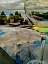 Dog laying by glass of wine on the table under the clouds