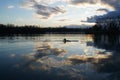 Reflection of clouds on the surface of the lake and the silhouette of the rower Royalty Free Stock Photo