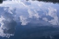 Reflection of clouds and surrounding nature in the water of a granite quarry, beautiful water surface, background Royalty Free Stock Photo