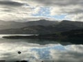 Reflection of the cloudy blue sky on the surface of the water in Akaroa Harbour, New Zealand Royalty Free Stock Photo