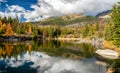 Reflection of coniferous trees and clouds on a surface of the water. Tarn Rakytovske pliesko in High Tatras mountains in Slovakia Royalty Free Stock Photo