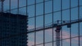 Reflection of construction crane and building on glass facade at dusk Royalty Free Stock Photo
