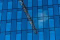 Reflection of a construction crane in the windows of a high rise building