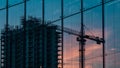 Reflection of a construction site with a crane on a modern glass building facade Royalty Free Stock Photo