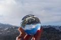 Reflection in a crystal ball of a mountain landscape with snow on a sunny day and blue sky. winter photo. Royalty Free Stock Photo