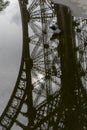 Reflection of Eiffel tower in a puddle in Paris France.