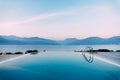 Reflection of the evening sky in the smooth water of the pool near the sea, against the backdrop of the mountains. Royalty Free Stock Photo