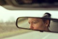 Reflection of female face in car rearview mirror Royalty Free Stock Photo