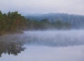 Reflection of the forest in a foggy lake. Calm autumn landscape Royalty Free Stock Photo