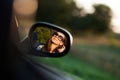 Reflection of a gorgeous young dark-haired girl in sunglasses in a side mirror of a car. Royalty Free Stock Photo