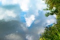 Reflection of green trees and blue sky with clouds Royalty Free Stock Photo