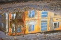 Reflection of a house building in an autumn puddle on the asphalt. Royalty Free Stock Photo