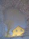 A reflection of a house in a puddle