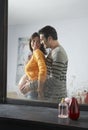 Reflection Of Man Embracing Pregnant Woman