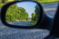 Reflection in the mirror of a car of an asphalt road with white markings. Royalty Free Stock Photo