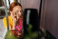 Reflection mirror of focused young woman using contour brush drawing arrows on eyelids. Beautiful ginger female applying Royalty Free Stock Photo