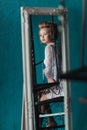 Reflection in the mirror modest Beautiful blond bride in white negligee sitting on the black wrought iron stairs. Royalty Free Stock Photo