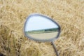 Reflection in the mirror of a motorcycle fields of cereal crops. Royalty Free Stock Photo