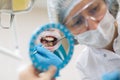 Reflection in the mirror mouth and teeth, woman dentist doing teeth checkup of man Royalty Free Stock Photo