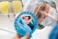 Reflection in the mirror mouth and teeth, woman dentist doing teeth checkup of guy Royalty Free Stock Photo