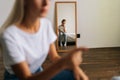 Reflection in mirror offended little girl looking at camera during unrecognizable irritated mother scolding at stubborn Royalty Free Stock Photo