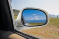 Reflection in the mirror of a riding white car of large altai mo Royalty Free Stock Photo