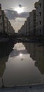 Reflection of modern buildings over stagnant rain water over under construction road. Royalty Free Stock Photo