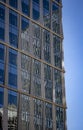 Reflection of a modern office building into the glass of another modern office building with line patterns Royalty Free Stock Photo