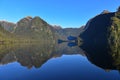 Reflection of mountains along the fiord of Doubtful Sound in Fiordland National Park in New Zealand