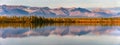 Reflection of mountains on a calm lake at sunset or sunrise. Panorama of autumn landscape in Yakutia, Sakha Republic, Russia. Beau