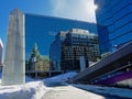 Reflection of neogothic building and modern skyscraper in the wal of a glass and steel building