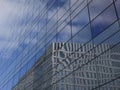 reflection of an office building and a cloudy sky in a glass facade Royalty Free Stock Photo