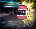 Reflection of old cars in a puddle