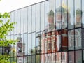 Old church reflection in wall of modern building