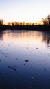 Reflection of orange sunset and trees in ice of frozen river in winter, abstraction Royalty Free Stock Photo