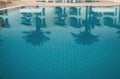 Reflection of palm trees and buildings in the pool water. Royalty Free Stock Photo